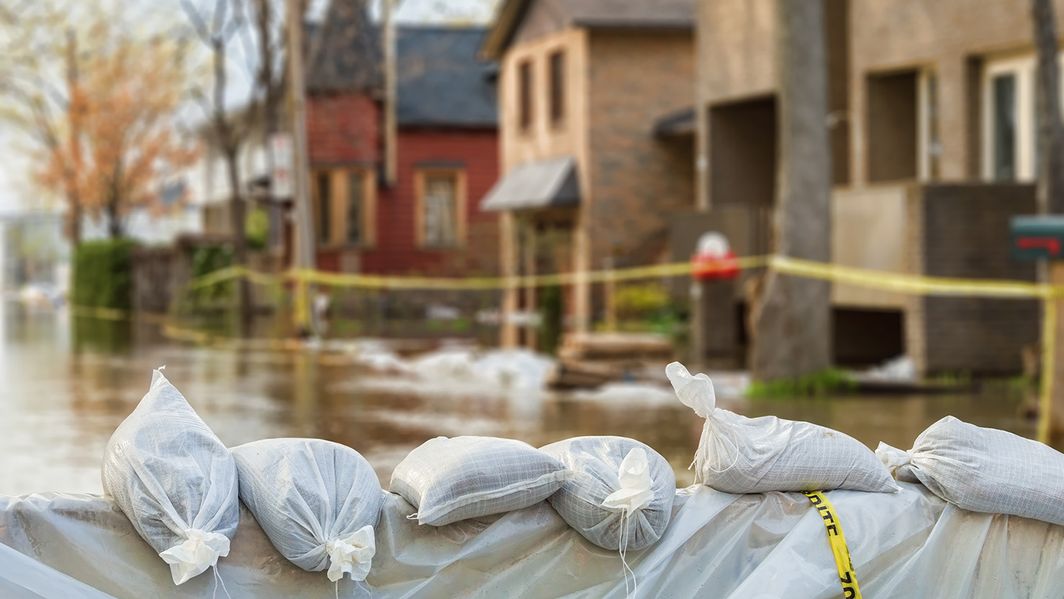 Sandsäcke liegen in einer durchfluteteten Straße 