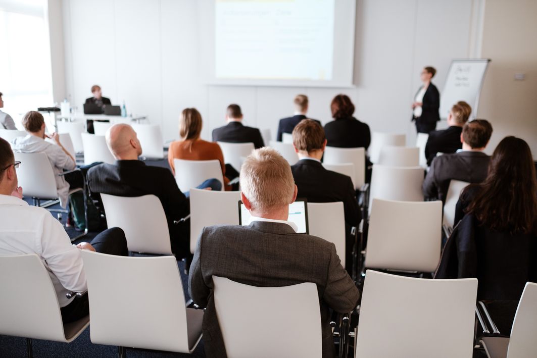 Menschen sitzen auf Stühlen in einem Konferenzraum