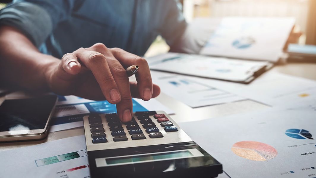 Status Quo des Forderungsmanagements Mann tippt Zahlen in einen Taschenrechner