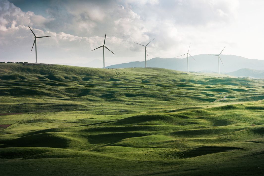 Eine grüne Landschaft auf dem Windräder zu sehen sind