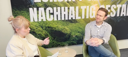 Zwei Menschen die aus Sesseln sitzen und gemeinsam im Gespräch sind
