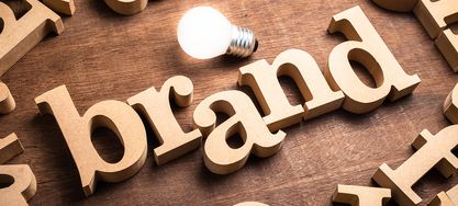 Einige Buchstaben liegen verteilt auf einem Tisch mit einer Glühbirne 