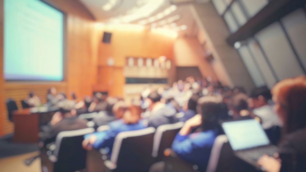 Viele Menschen sitzen in einem Hörsaal