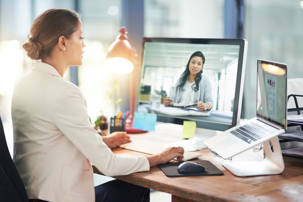 Eine Frau in einem weißen Blazer macht ein Videocall.