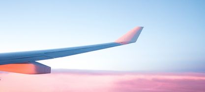 Flugzeug durch blau-rosa gefärbten Himmel