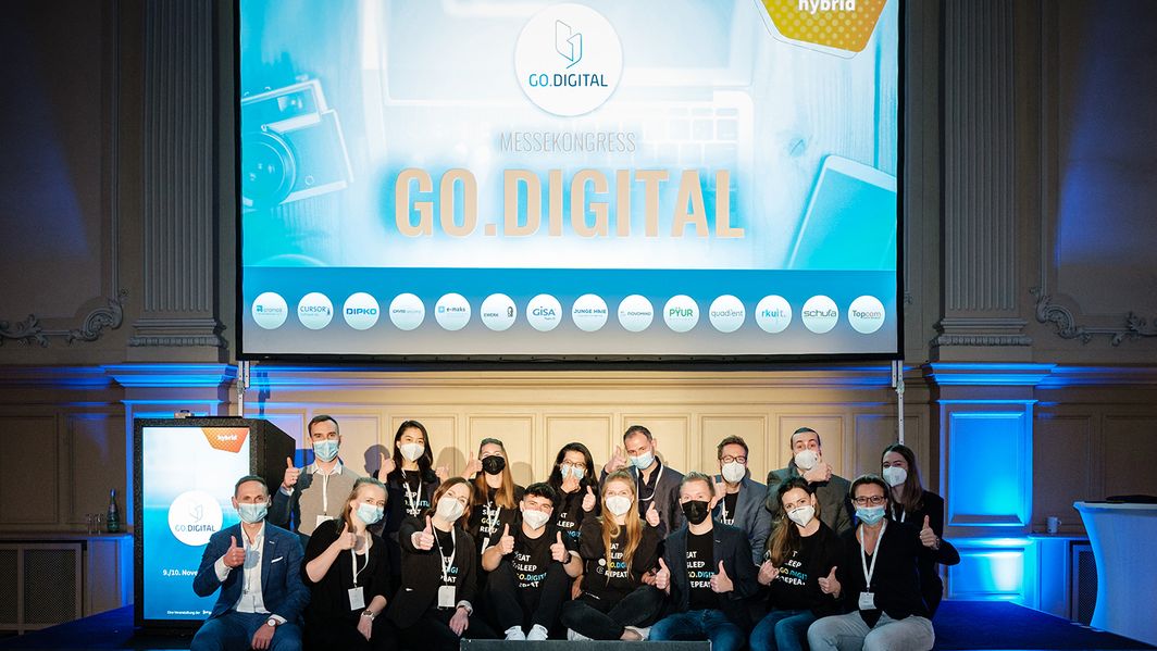 Team GO.DIGITAL 2021 Ein Team sitzt vor der GO.DIGITAL-Leinwand