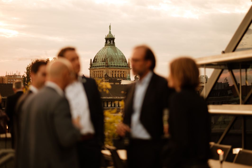 Menschen stehen zusammen und reden, im Hintergrund ist das Bundesverwaltungsgericht zu sehen.
