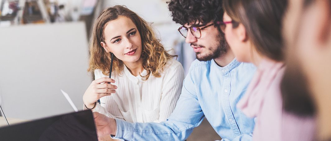 Mehrere Personen arbeiten gemeinsam an einem Tisch