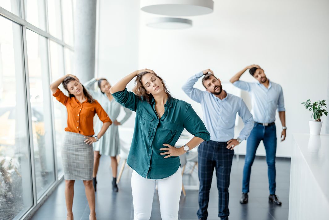 Mitarbeitende die zusammen Sport im Büro machen